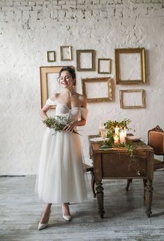 a woman standing next to a table with candles