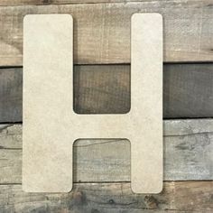 the letter h is made out of wood and sits on top of a wooden surface