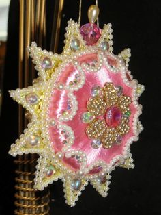 an ornament made out of glass beads and beadwork on a black background