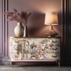 a dresser with flowers on it next to a lamp