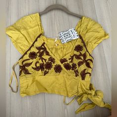 Free People Sahara Embroidered Crop Top In Mustard Yellow Size Xs Nwt- New With Sample Tags. V Neckline Cropped Floral Embroidered Blouse, With Pleated Detailing And A Smocked Back Tie Front Closure Rustic,Boho, Bohemian, Country, Western, Festival, Stagecoach, Embroidered, Crochet, Spring, Summer, Crop, Free People Yellow Floral Embroidered Top For Spring, Yellow Bohemian Crop Top For Spring, Yellow Embroidered Short Sleeve Top For Spring, Spring Yellow Top With Floral Embroidery, Fitted Yellow Tops With Floral Embroidery, Handmade Yellow Bohemian Top, Casual Yellow Embroidered Short Sleeve Top, Yellow Cotton Tops With Floral Embroidery, Fitted Embroidered Yellow Tops