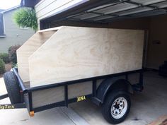 a trailer with a large wooden box attached to it's back end in a driveway