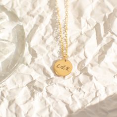 "Not too big and not too small, our 13mm circle necklace, fits just right. A perfect everyday necklace that will layer beautifully with your other chain and pendant necklaces. Engrave a heartfelt word, a special year, or a short name of a loved one. Free Engraving for a limited time! NECKLACE DETAILS ⚬ 14k gold-filled disc and chain. ⚬ Disc measures 13mm (0.51\") ⚬ Chain in your choice of 16\", 18\", or 20\" length ⚬ Spring ring clasp closure. ⚬ Personalized engraving of 1-4 characters (includin Yellow Gold Round Disc Necklace For Everyday, Everyday Tarnish Resistant Charm Necklace With Round Pendant, Everyday Yellow Gold Round Disc Necklace, Classic Tarnish Resistant Coin Necklace For Gift, Classic Tarnish-resistant Coin Necklace For Gift, Circle Charm Necklace In Yellow Gold Sterling Silver, 14k Gold Filled Round Charm Necklace, 14k Gold Round Charm Necklace, Dainty Round Initial Necklace As Gift For Her