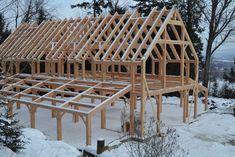 a house under construction in the middle of winter with lots of snow on the ground