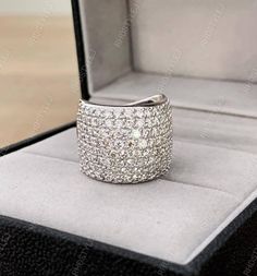 an open box with a ring in it and some diamonds on the inside of it