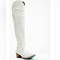 a pair of white cowboy boots with pearls on the heel and laces around the ankles