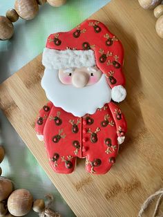 a santa clause cookie sitting on top of a wooden cutting board