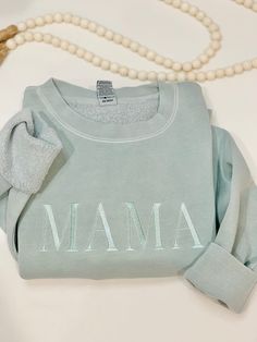 "Pigment Sage Embroidered MAMA DADA Sweatshirt, Embroidered Crewneck Sweatshirt, Mother's day gift, Custom Embroidered Mom Dad Sweatshirt This Monochromatic Customizable Embroidered Neutral Sweatshirt is the perfect gift for any mom for any occasion, Mother's day gift, Christmas, Birthdays, Pregnancy Reveal, or a custom Baby Shower Gift for mom! This sweatshirt can be customized with a short word like (MAMA, DADA, MIMI, NANA, PAPA, WIFE, HUBBY, BRIDE, GROOM etc.) and up to 7 letters (GRANDMA, GR Mom Crewneck Sweatshirt, Mama Embroidered Sweatshirt, Dad Baby Shower Gift, Baby Got Back, Embroidery Sweatshirt, Baby Shower Presents, Mommy Baby, Embroidered Crewneck, Fun Sweatshirts