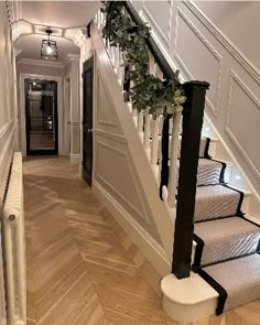 the stairs in this house are decorated with wreaths and greenery on each handrail