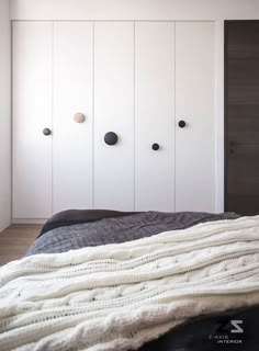 a bedroom with white cupboards and black bedding