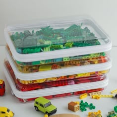 a stack of plastic containers filled with different types of toy cars and trucks next to each other