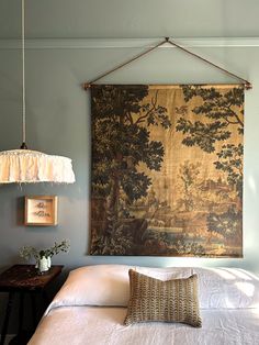 a large tapestry hanging on the wall above a bed