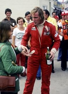 a man in a racing suit talking to a woman