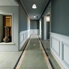 a long hallway with white walls and beige trim on the floor, leading to an open door