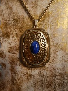 This stunning gold plated locket features a cobalt blue stone in the center and can fit 2 photos inside. It is in excellent condition. Measurements- Bail to end of pendant: 2.5 inches Width: 1.5 inches Chain: 14 inches *ALL ITEMS ARE FINAL SALE AND COME FROM A SMOKE FREE HOME. ITEMS MAY HAVE SCUFFS, ODOR STAINS/MARKS OR HOLES. I DO NOT INSPECT ANY ITEMS SOLD UNLESS INDICATED IN PHOTOS OR DESCRIPTION. ALL ITEMS ARE PURCHASED AS IS AND ARE SOLD AS IS.* Blue Hallmarked Medallion Jewelry, Blue Medallion Jewelry For Anniversary, Blue Brass Jewelry With Vintage Charm, Blue Brass Necklace With Vintage Charm, Blue Brass Jewelry For Anniversary, Collectible Costume Jewelry Locket, Antique Blue Jewelry With Large Pendant, Antique Blue Brass Jewelry, Blue Oval Locket Necklace