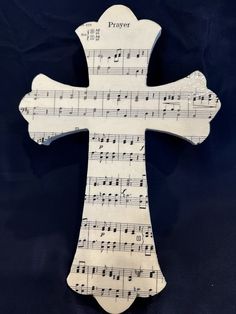 a cross made out of sheet music with the word prayer on it's side