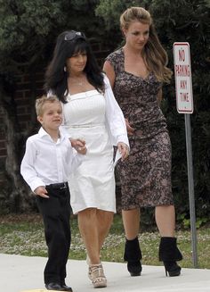 two women and a boy are walking down the street