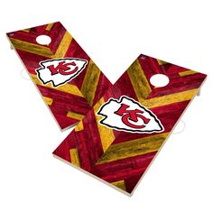 two red and yellow striped cornholes with the kansas chiefs logo on them