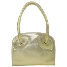 Laura Biagiotti Attributed Gold Leather Handbag, 1970's | From a unique collection of rare vintage Top Handle Bags at https://www.1stdibs.com/fashion/handbags-purses-bags/top-handle-bags/. Modern Yellow Gold Bag With Gold-tone Hardware, Gold Satchel Shoulder Bag With Brass Hardware, Vintage Gold Shoulder Bag With Gold-tone Hardware, Gold Shoulder Bag With Top Handle And Brass Hardware, Gold Top Handle Shoulder Bag With Brass Hardware, Classic Gold Shoulder Bag For Evening, Designer Gold Shoulder Bag With Brass Hardware, Designer Gold Satchel Bag, Luxury Metallic Shoulder Bag For Evening