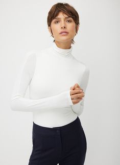 An elevated and comfortable turtleneck thong bodysuit with a high-performance update. Featuring a shaped sleeve and shoulder darts for a streamlined fit, plus built-in stretch that won’t slow you down. Use this breathable base layer to effortlessly build outfits or wear it solo with trousers for a clean, sophisticated office look. With the Ascend Turtleneck Bodysuit, getting dressed is a breeze—what you do with the rest of your day is up to you. Fall Bodysuit With Thumbholes And Minimal Stretch, Sleek Turtleneck Second-skin Bodysuit, Sleek Second-skin Turtleneck Bodysuit, Sleek High Stretch Turtleneck Bodysuit, Sleek High-stretch Turtleneck Bodysuit, Classic Long Sleeve Bodysuit For Work, Winter Workwear Stretch Bodysuit, Chic Fitted Bodysuit For Layering, Versatile Fitted Turtleneck For Layering