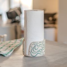 a roll of toilet paper sitting on top of a counter next to a napkin holder