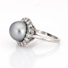 This is part of Chairish’s Fine Jewelry assortment.  Finely detailed vintage Van Cleef & Arpels South Sea Pearl & diamond ring crafted in platinum (circa 1980s to 1990s).   South Sea Pearl measures 11mm. 16 diamonds total an estimated 1.20 carats (estimated at E-F colour and VVS2 clarity). The pearl is lustrous with a light gunmetal grey colour & soft peacock rose overtones.   The mounting is made by Van Cleef & Arpels, signed and numbered with a special designation of "mtg only" for mounting on White Gold Pearl Ring With Diamond Center Stone, Timeless Pearl Ring With Diamond Accents For Anniversary, Timeless Anniversary Pearl Ring With Diamond Accents, Hallmarked Platinum Cluster Ring, White Gold Pearl Ring With Brilliant Cut For Anniversary, Timeless Diamond Cluster Ring With 17 Jewels, Timeless Diamond Pearl Ring With Center Stone, Anniversary White Gold Pearl Ring With Brilliant Cut, Classic Oval Pearl Ring With Diamond Accents