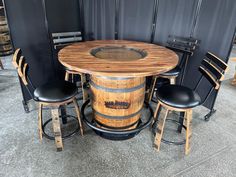 a wooden barrel table surrounded by stools and chairs