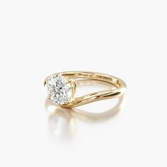 a yellow gold engagement ring with a single diamond in the center, on a white background