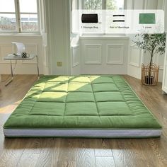 a green mattress sitting on top of a hard wood floor next to a white door