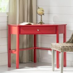 a red desk with a chair next to it and a lamp on top of it