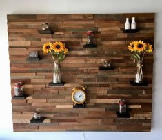 a wooden wall with vases and sunflowers on it, along with an alarm clock