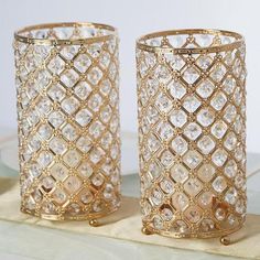 two gold colored glass vases sitting on top of a table