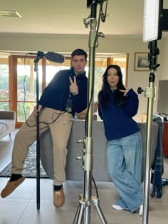 a man and woman sitting on a couch in front of a camera set up for a photo shoot