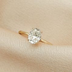 a diamond ring sitting on top of a white cloth