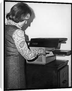 an old black and white photo of a woman typing