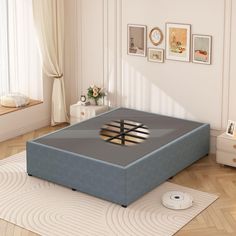 a blue ottoman bed sitting on top of a hard wood floor next to a window