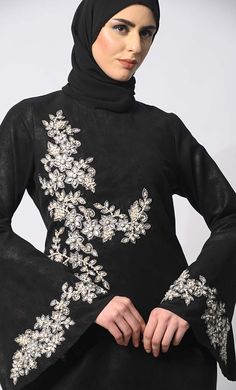 Step into the grace and charm of Eid celebrations with our exclusive Abaya Collection, featuring the epitome of elegance and sophistication. Our machine embroidered Abaya, meticulously adorned with pearl and stone handwork, is a testament to timeless beauty and exquisite craftsmanship. Crafted with meticulous attention to detail, this Abaya boasts delicate machine and Hand embroidery with stones and Pearls that adorns every inch, creating a mesmerizing tapestry of intricate patterns. Each stitch reflects a dedication to perfection, enhancing the allure of this traditional garment. The Abaya also features Round neck, flared sleeves , back zip closure and a loose belt for a cinched waist silhouette effect. Size & FitModel height is 5’9’ and is wearing a Small sizeMaterial & CareMaterial: Kor Luxury Long Sleeve Abaya With Floral Embroidery, Evening Black Embellished Abaya, Blue Abaya, Elegant Embroidered Black Abaya, Embellished Black Floor-length Abaya, Black Embroidered Floor-length Abaya, Black Abaya, Flared Sleeves, Timeless Beauty