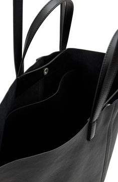 Bring it all with you—we're talking your essentials, laptop and an extra layer for unpredictable weather—with this leather tote crafted with winged gussets that enhance its carrying capacity. You can hold it in hand with the top handles or sling it over your shoulder with the longer straps when it's packed to the max. Top snap closure Top carry handles; shoulder straps Interior wall pocket Leather lining Leather Imported Allsaints Modern Leather Bags, Allsaints Leather Bags For Everyday Use, Allsaints Leather Everyday Bag, Travel Bags In Textured Faux Leather, Textured Faux Leather Travel Bags, Allsaints Black Bags For Everyday Use, Allsaints Black Bags For Daily Use, Allsaints Bags For Everyday Use, Allsaints Black Shoulder Bag For Everyday