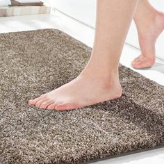 a person with bare feet standing on a rug