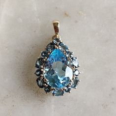 This stunning Pendant is set in 14k Solid Yellow Gold with Natural Sky Blue Topaz with utmost precision. It is a unique gemstone Pendant for nearly every occasion and is completely hassle-free jewelry. ITEM DETAILS: * GEM: Sky Blue Topaz * GEM SIZE: 10x14mm * GEM SHAPE: Oval * GEM: London Blue Topaz * GEM SIZE: 3x4mm 7pcs * GEM SHAPE: Oval * GEM: London Blue Topaz * GEM SIZE: 2.5mm 7pcs * GEM SHAPE: Round *TOTAL GEM  WEIGHT: 8.10 carats * Gold Purity: 14KT (58.33% approx.) * Gold Weight: 1.81 gram * Total Weight of the Pendant: 3.43 gram The Gold purity is guaranteed and it comes with authentic 14KT gold hallmark. Since my items are handmade, they are absolutely nickel and lead free. CUSTOMIZATION: * Gemstone customization is available and it can be substituted with a gem of your choice. K Handmade Jewelry Box, Gold Topaz, Blue Topaz Pendant, Bezel Pendant, Sky Blue Topaz, London Blue, Unique Gemstones, London Blue Topaz, Free Jewelry