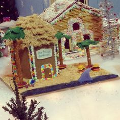 a gingerbread house with palm trees and decorations on the front porch is decorated for christmas