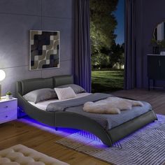 a bedroom with a lit up bed in the middle and purple lighting on the side