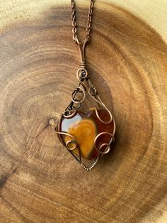 "A gorgeous Carnelian heart carving wire wrapped in copper wire, antiques and polished, on a 24\" antique copper chain." Vintage Brown Heart-shaped Jewelry, Bohemian Brown Heart-shaped Jewelry, Handmade Copper Heart Pendant Jewelry, Handmade Amber Heart Jewelry, Handmade Heart-shaped Amber Jewelry, Artisan Rust-colored Necklace For Gifts, Brown Heart-shaped Bohemian Necklace, Brown Bohemian Heart Necklaces, Bohemian Brown Heart-shaped Necklace