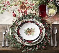 a christmas place setting with holly and berries