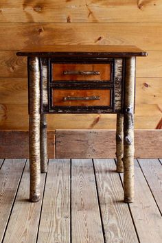 a small wooden table sitting on top of a hard wood floor next to a wall