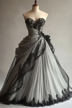 a dress on a mannequin with black and white laces, in front of a gray background