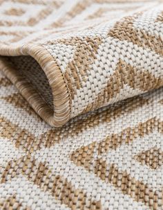 a close up view of the woven material on a rug with brown and white patterns