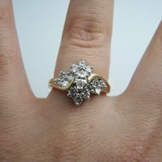 a woman's hand with a diamond ring on top of her finger, showing the center stone