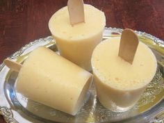 three popsicles sitting on top of a silver plate with toothpicks sticking out of them