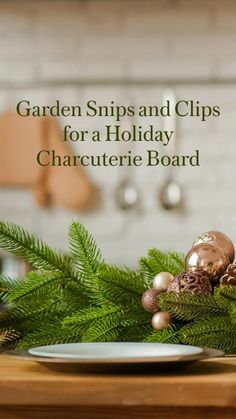 a white plate sitting on top of a wooden table next to a christmas tree branch